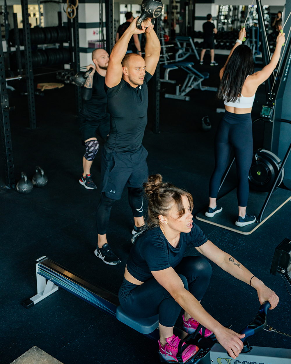Iron & Co. coach guiding a member through a strength workout